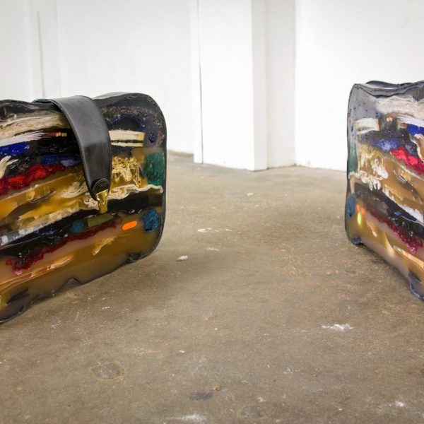 a sculpture of a suitcase cut in two and encased in resin