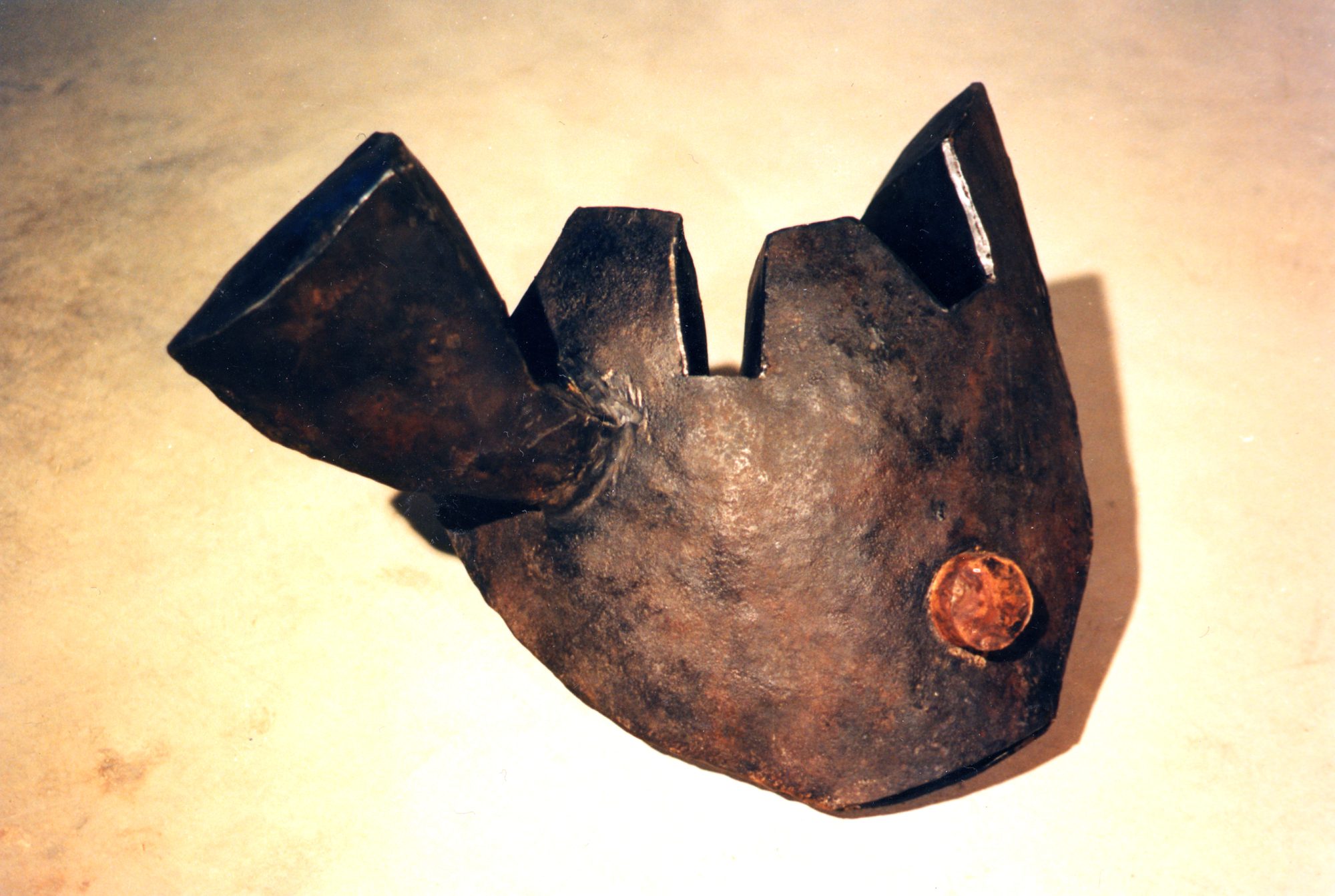 Exploring an uneasy ecological balance between nature and the man-made, this sculpture considers in a marine context the metamorphosis of a fish with a radioactive container. The eye is a canister lid, the gills behind are filters.