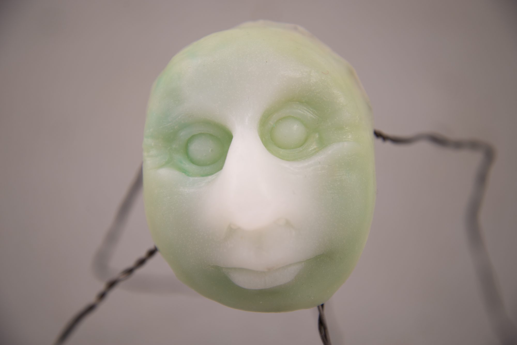 Close up of silicone cast sculpture of green human like face