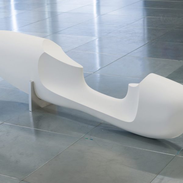 a smooth white oblong sculpture on the floor