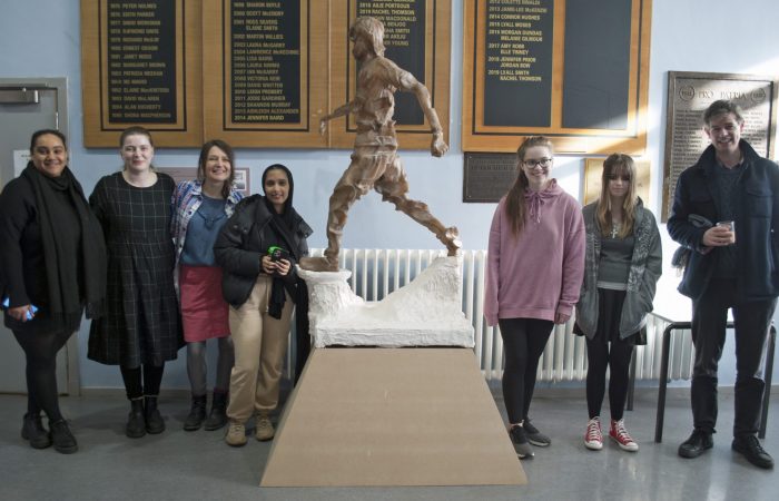 Team Sculpture participants stand next to Rachel Lowther's sculpture 'Mohammad Plays'